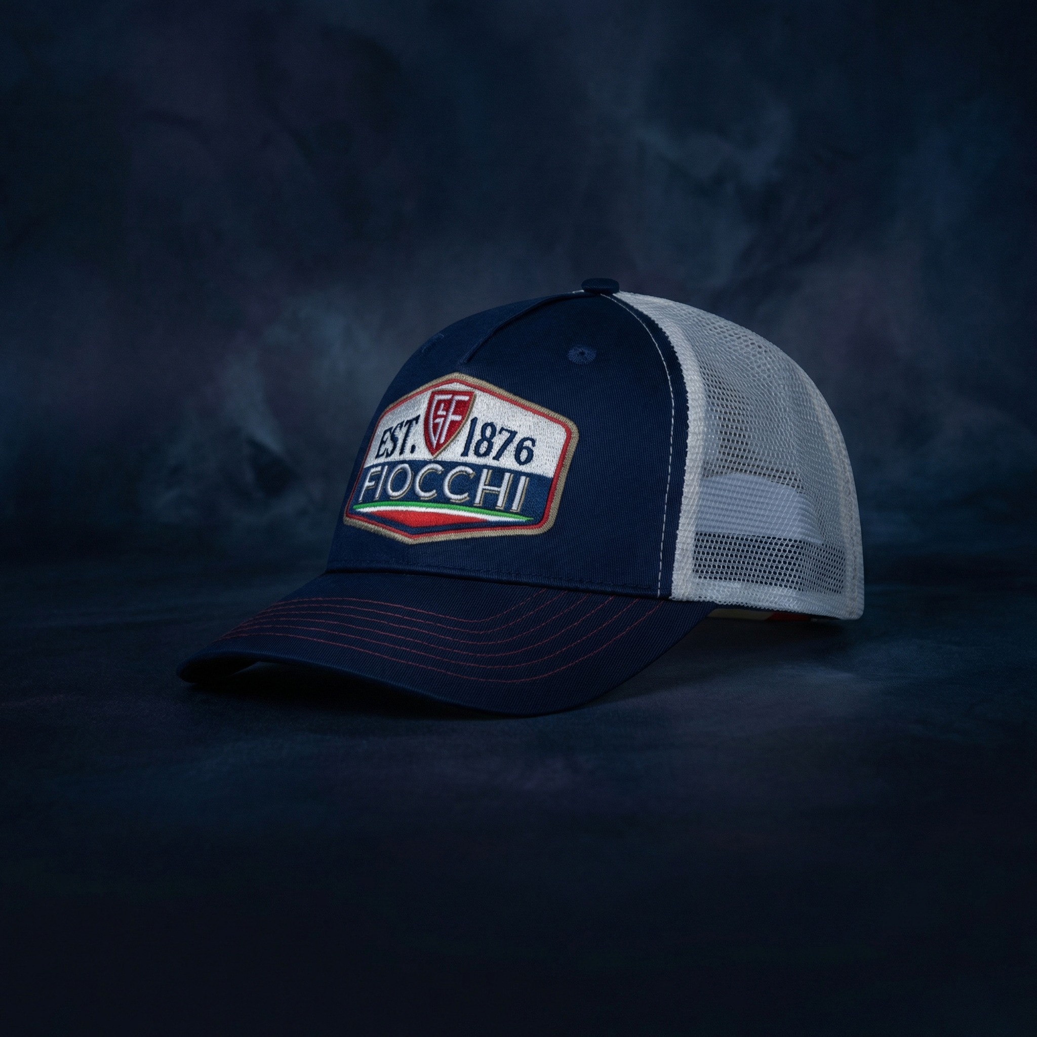 Bespoke navy and white Fiocchi 1876 trucker cap with premium embroidery, studio lit