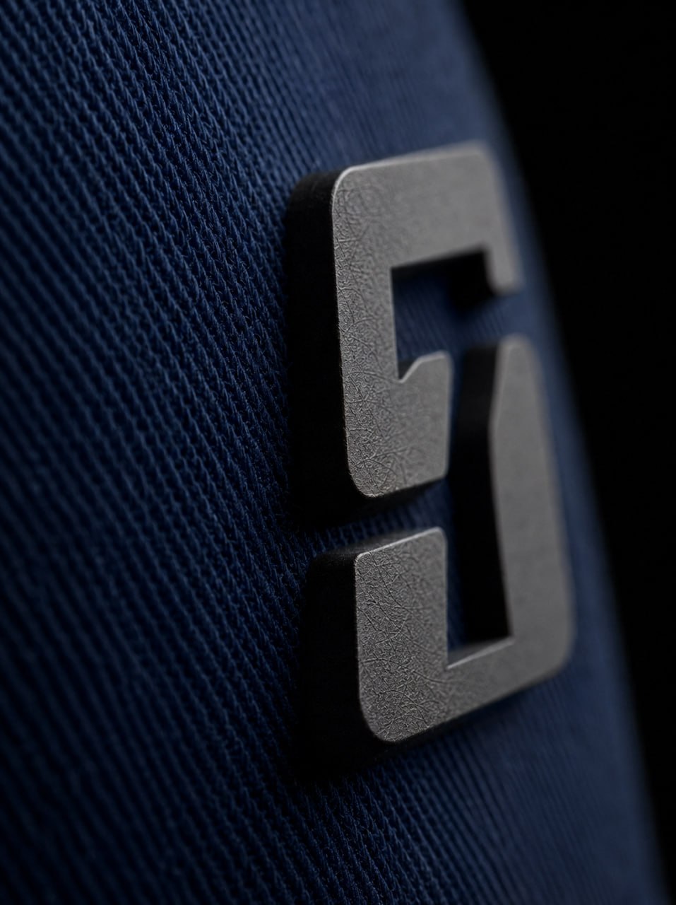 Macro of the raised die-cut S7 mark on a bespoke navy Solid7 Headwear cap